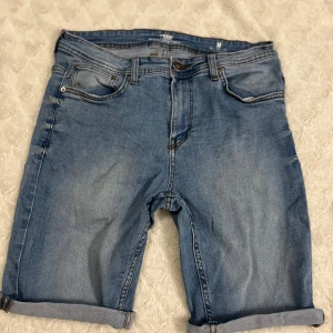 Blå jeansshorts från new yorker - Säljer ett par snygga blå jeansshorts från New Yorker i storlek M. De har en klassisk femficksdesign och är perfekt för sommaren. Shortsen har en normal passform och är i nyskick. Perfekta för både vardag och fest!
