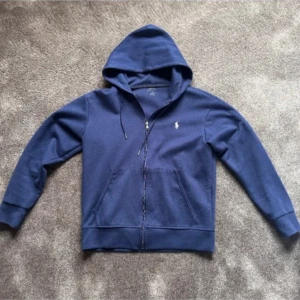 Ralph lauren zip-up - Ralph Lauren zip-up tröja i stort sätt perfekt skick, använd sällan. Tröjon går ny för cirka 2000 därför säljer jag för 750kr. Tröjan säljs eftersom jag nu vuxit ur den. Hör av er om övriga frågor!