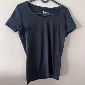 Svart t-shirt från Basic - Säljer en enkel och stilren svart t-shirt från Basic i storlek M. Den är gjord av ekologisk bomull och har en normal passform med korta ärmar. Perfekt för vardagsbruk eller som basplagg i garderoben. 🖤