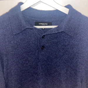 Mörkblå tröja från Lawrence Grey 100%kashmir  - Snygg mörkblå 100% Kashmir tröja från Lawrence Grey med krage och knappar framtill. Perfekt för kyligare dagar med sin mjuka och bekväma design.