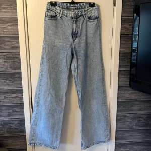 Ljusblå jeans med hög midja - Säljer ett par ljusblå jeansfrån monki med hög midja och en avslappnad passform. De har en klassisk femficksdesign och är tillverkade i 100% bomull. 