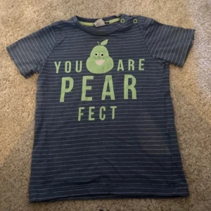 Blå randig t-shirt med päronmotiv - Söt blå randig t-shirt med texten 'You are pearfect' och ett päronmotiv på framsidan. Perfekt för en avslappnad stil.