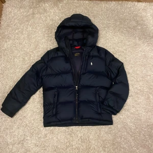 Ralph lauren jacka - Super snygg och bra kvalite! Den har en slitning men syns verkligen inte för det är på insidan av jackan 🥰 storlek 14-16y nypris 2995