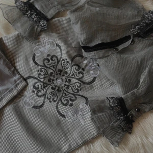 Grå set med spetsdetaljer - Elegant grå set med vackra spetsdetaljer på ärmslut och en broderad design framtill. Klänningen har långa ärmar och en diskret knäppning. Perfekt för en stilfull look.