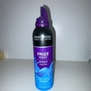 Frizz Ease Dream Curls Mousse - Återupplivar lockar med definition och stadga för naturligt lockigt hår. Moussen kontrollerar frizz och innehåller värmeskydd. Perfekt för att styla håret med en mjuk och naturlig finish.