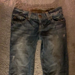 lågmidjade jeans Guess - Snygga lågmidjade blå jeans från Guess med broderade detaljer på bakfickorna! är insydda i midjan (inget som syns) så passar storlek XS 💕