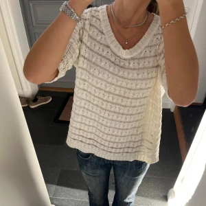 Vit stickad tröja  - Vit stickad tröja med guldiga ränder från Indiska i storlek S, skulle säga att den även passar M. Fint skick. Använd gärna köp nu!