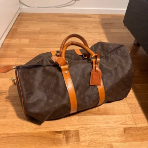 LV väska  - Snygg brun LV  resväska med monogram och läderdetaljer. Perfekt för resor med stil. Väskan har en dragkedja och bekväma handtag i läder. Snabb affärs kan pris diskuteras 