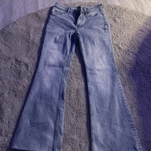 Blå bootcut jeans - Snygga blå bootcut jeans med klassisk femficksdesign. Perfekta för en avslappnad stil med en touch av retro. Passar bra till både sneakers och klackar.
