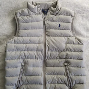 Jätte fin Ralph Lauren väst! - Hej säljer en otroligt snygg Polo Ralph Lauren Väst!! Västen är i 9/10 skick i storlek L 14-16 men passar som en S. Den är super snygg och otroligt stilren, helt perfekt för dom kommande kalla månaderna! Skriv om ni har några fler frågor, Pris kan såklart diskuteras!:)