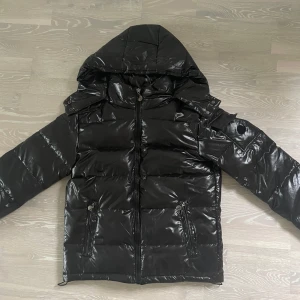 Svart pufferjacka med huva - Snygg svart pufferjacka som är helt ny. Säljer på grund av att den inte passar mig💞 Är i storlek S men passar en M.                                                  Nypris: 900 kr