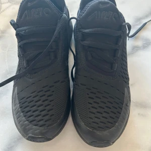 Svarta Nike Air Max sneakers - Säljer ett par svarta Nike Air Max sneakers med snörning. Skorna har en luftig design med synlig luftdämpning i sulan för extra komfort. Perfekta för en sportig look.