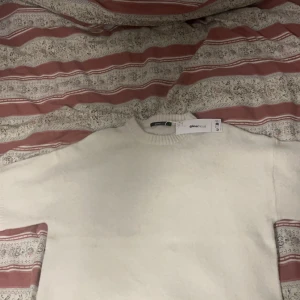 Vit tröja Gina Tricot - Säljer en stilren vit tröja från Gina Tricot i storlek S. Tröjan har en klassisk design med rund hals. Perfekt för en enkel och snygg look.