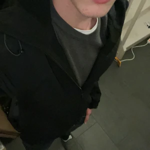 Svart jacka med huva - Säljer en stilren svart jacka med huva. Jackan har dragkedja och långa ärmar, perfekt för kyligare dagar. Enkel och funktionell design som passar till det mesta.