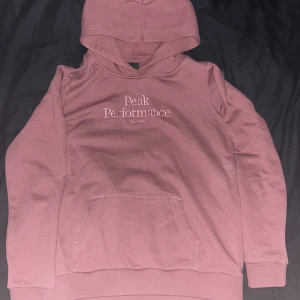 Rosa hoodie från Peak Performance - Rosa hoodie från peak preformance helt nytt skick och med lurvig insida så e den riktigt vart o skönt för dens kyla 