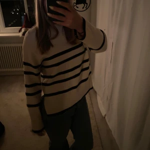 Randig tröja från Vero Moda - Säljer en stilren beige tröja från Vero Moda med svarta ränder. Tröjan har långa ärmar och ribbade detaljer vid ärmslut och nederkant. Pris kan diskuteras. Skriv ifall du har frågor🩷