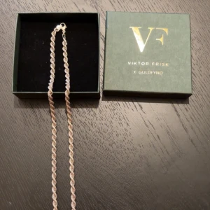 Halsband från Viktor Frisk x Guldfynd - Elegant halsband i silver från Viktor Frisk x Guldfynd. Halsbandet har en vriden design som ger en unik och stilren look. Perfekt för att lyfta vilken outfit som helst. Halsbandet är rengjort vilket ger den en ny glans.