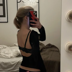 Svart långärmad topp med öppen rygg från Ginatricot i storlek xxs  - Snygg svart långärmad topp med en stilren design och öppen rygg. Perfekt för en kväll ute eller en speciell tillställning. Toppen har en tight passform som framhäver figuren.