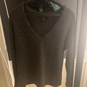 Mörkgrå tröja från Amisu - Säljer en stilren mörkgrå tröja från Amisu med v-ringning. Tröjan har långa ärmar och är perfekt för kyligare dagar. Passar bra till både jeans och kjol.
