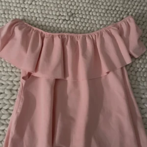 Rosa offshoulder topp med volang - Säljer en superfin rosa offshoulder topp med volangdetaljer.❤️