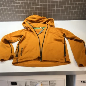 Barnhoodie - Houdini fleecetröja i strlk 130. Väl använd med ett litet hål på ena ärmen men annars i fint skick. 