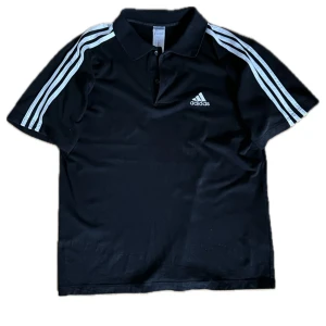 Drain Y2k Svart Adidas Piké - Riktigt snygg adidas piké. I bra skick. Bredd: 52 cm. Längd: 66 cm. Ställ gärna frågor. Priset kan diskuteras.