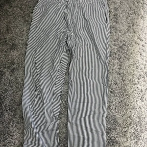 Randiga pyjamas byxor - Ett par mörk grå/vit randiga pyjamas byxor 