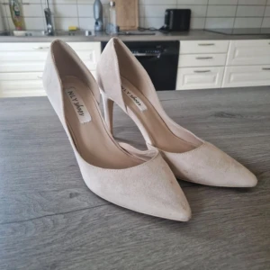 Nelly beige high heels  - Suede-like material, normal rubbing/stain here and there that is not obvious when worn. Can probably be cleaned with shoe rubber. Otherwise in good condition.