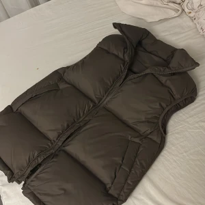 Väst - Väldigt fin och puffig väst från & other stories, i färgen brun. Den är i storlek 32 men passar även 34 och 36. Den är använd endast några gånger. Nypris 959kr