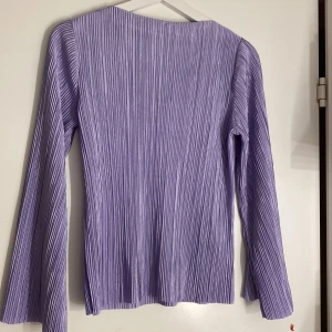 Lila plisserad topp - Lila långärmad plisserad topp från stockh lm studios med utsvängda armar i storlek s