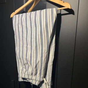 Randiga tygbyxor från Weekday - Säljer ett par randiga tygbyxor från Weekday, perfekt för varma dagar. Byxorna har en baggy passform och passar dig som är runt omkring 180 cm lång. Skicket är väldigt bra då jag prioriterat andra byxor och inte använt dessa så mycket