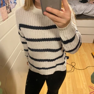 Vit och marinblå randig stickad tröja från 157 - Säljer en supermysig vit och marinblå randig stickad tröja från 157. Den har en skön, normal passform och är perfekt för kallare tider eller mysiga sommarkvällar💕 Använd men ändå i bra skick💕 xs men passar även S. Säljer då den inte kommer till använ