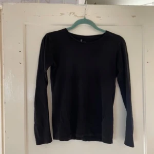 Svart långärmad tröja från Åhléns - Säljer en enkel och stilren svart långärmad tröja från Åhléns. Perfekt basplagg för alla tillfällen. Tröjan är i storlek S (36/38) och har en normal passform. Ett måste i garderoben för höst och vinter!
