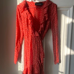 Realisation Par Klänning Röd - Realisation Par klänning Röd med stjärnor och volanger Wrap klänning 100 % silke Är jätte bra skick förutom missfärgning från deo under armarna, där av nerdraget pris  Liten i storleken, står M men passar en S