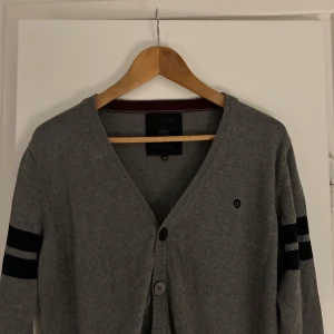 Grå kofta från Jack & Jones - Säljer en stilren grå kofta från Jack & Jones i storlek M. Superbekväm och lätt att matcha med andra plagg!