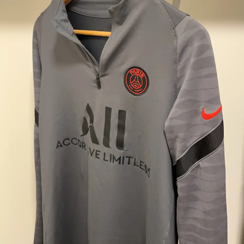 Säljer en grå långärmad träningströja från Nike med PSG-logga då jag inte använder längre. Perfekt för fotbollsträning eller som en snygg vardagströja. Storlek M men liten i storlek så kan även passa för dem med S.. Tröjor & Koftor.