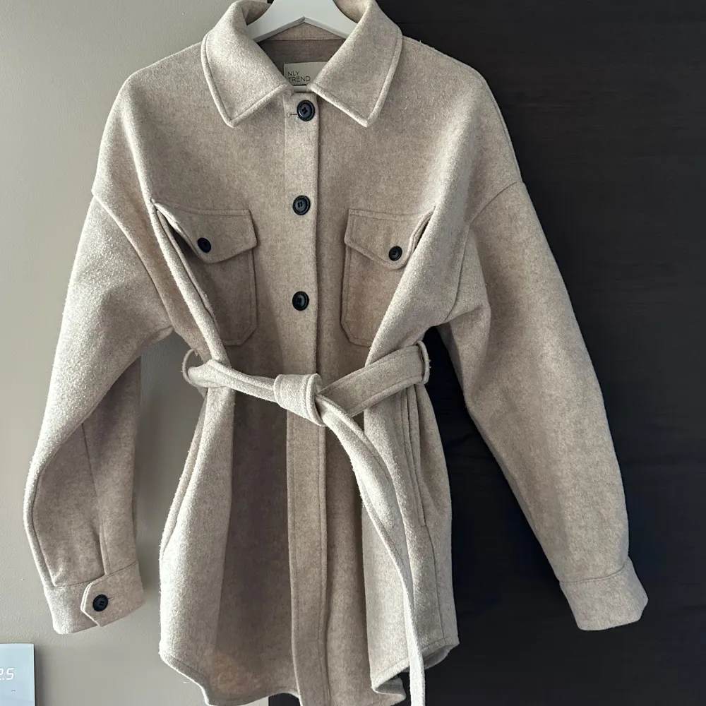 Säljer en superfin beige overshirt från Nelly i storlek 34. oversized modell så passar alla beroende på önskad passform. Är lite nopprig på visa ställe annars i bra skick utan defekter 💕. Jackor.