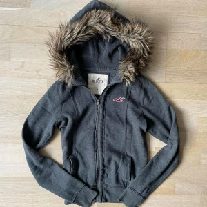 Vintage hollister zipup hoodie med päls! - Fraktar elr möts upp! Har ett väldigt litet hål och vid dragkedjan har den blivit ihopsydd från ett gammalt större hål! Se bilderna innan ni köper eller fråga mig för bättre bilder!! :)