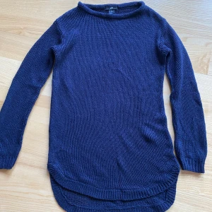 Mörkblå stickad tröja från H&M - Säljer en snygg mörkblå stickad tröja från H&M. Perfekt för kyliga dagar med sin långa ärmar och bekväma passform. Tröjan är i storlek XS och har en rund halsringning. Den är både stilren och mysig, perfekt för höst och vinter!