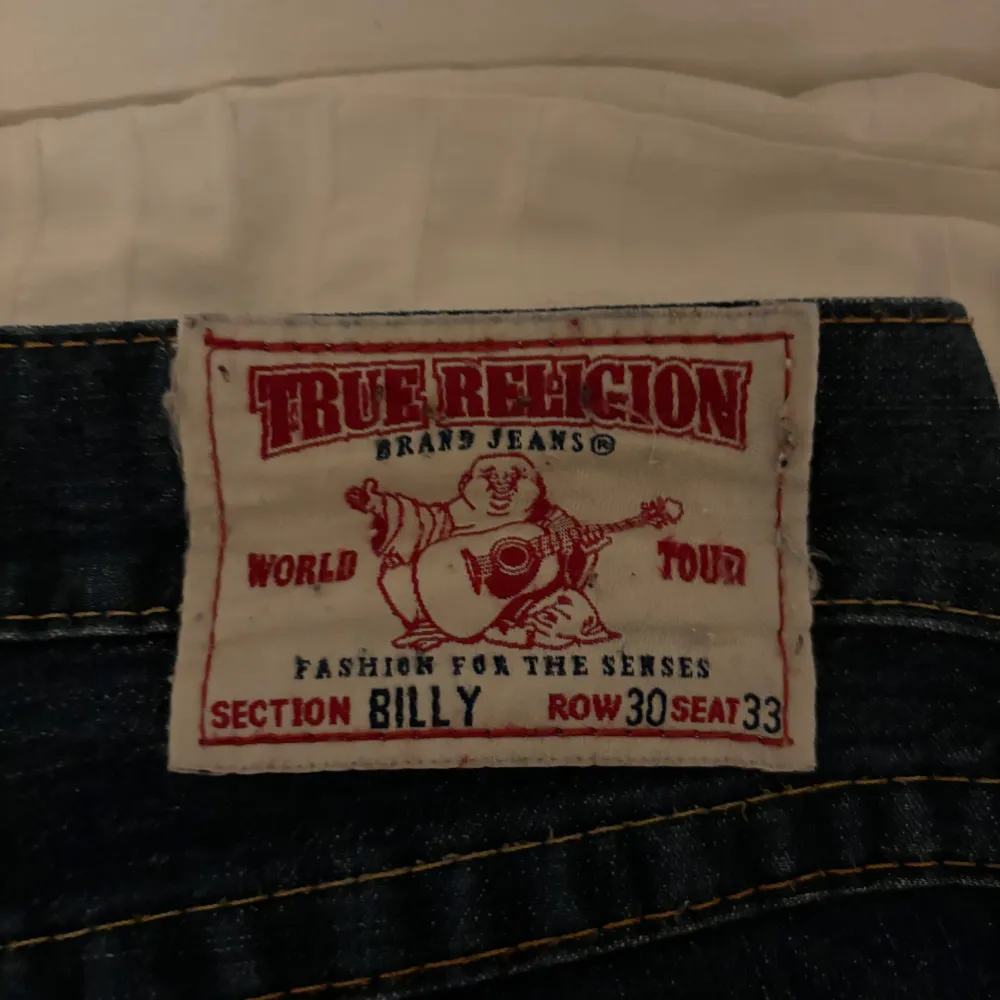 Ett par mörkblåa jeans från True Religion. Det är storlek 30 i midja och 33 i höften. Byxorna är smått nedgångna längst ner, men inte så illa, annars är dem överlag i riktigt bra skick! Jag är 166 och byxorna är ca 3 cm för långa för mig!. Jeans & Byxor.