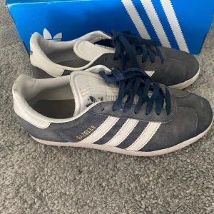 Adidas Gazelle - Säljer ett par snygga Adidas Gazelle. Skorna användes i 4-5 månader och är i bra skick med lite slitage på sulorna. Priset är ej hugget i sten! Boxen ingår.
