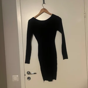 Svart klänning med guldkedja  - Säljer en elegant svart långärmad klänning. Den är tight och perfekt för festliga tillfällen. Har endast provat den.