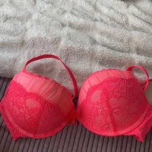 Röd spets-BH från Hunkemöller - Säljer en superfin röd BH från Hunkemöller i storlek 90C. Den har vacker spetsdetalj och justerbara axelband för perfekt passform. Perfekt för att känna sig extra fin till vardags eller speciella tillfällen. Använd fåtal gånger, så den är i bra skick. 🌹