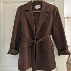 Brun kavaj med bälte - Lyxig brun kavaj med bälte i midjan. Går att använda både med eller utan bältet. Använd endast en gång.