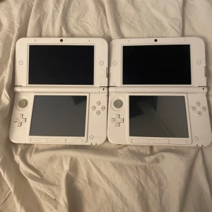 Vit Nintendo 3DS XL - Säljer två vita Nintendo 3DS XL. Båda enheterna är i bra skick med dubbla skärmar och klassiska kontroller. Perfekt för spel på språng! 🎮