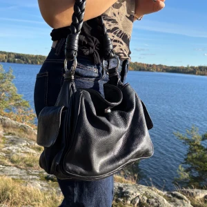 Svart väsks - En svart väska med flätad axelband. Mycket bra skick och bra med olika fack. Kontakta för vid frågor eller fler bilder🍁🤎