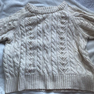 Vit stickad tröja från Zara - Säljer en superfin vit stickad t-shirt, tröja från Zara. Den har ett snyggt flätmönster och är perfekt för kyliga dagar. Tröjan är långärmad och har ribbade kanter som ger en mysig känsla. Passar perfekt till både jeans och kjol! Pris + frakt