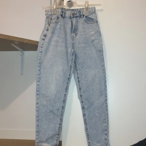 Ljusblå mom jeans från FB Sister - Säljer ett par ljusblå mom jeans från FB Sister. De har en hög midja och klassisk femficksdesign. Perfekta för en avslappnad stil med en vintage touch. Skinny jeans och lite slits i slutet av jeansen. Jättebra skick
