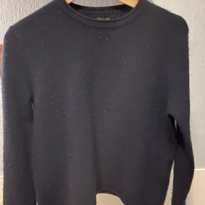 Svart tröja från Lisa Yang - Säljer en stilren svart tröja från Lisa Yang. Tröjan har en klassisk design med långa ärmar och rund hals. Storlek 1 