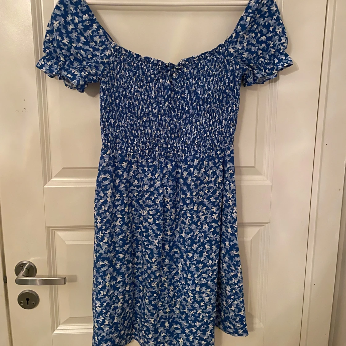 Blå klänning i ett fjärilstyg/ blommigt